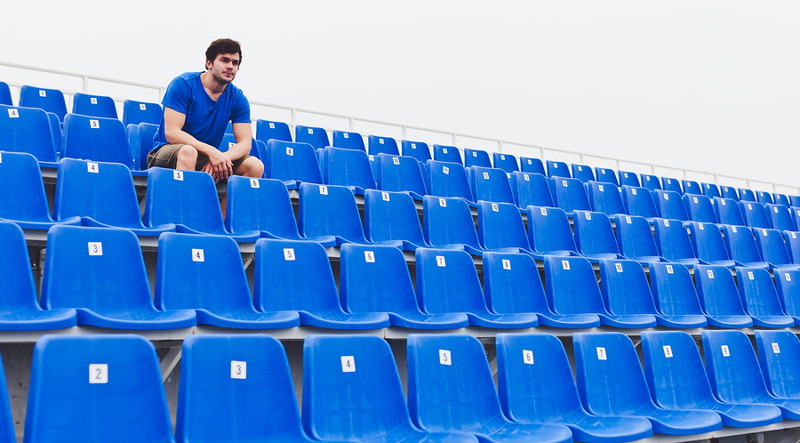 man sat alone in a stadium stand