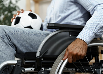 man in wheelchair holding football