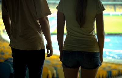 two people watch from stands in empty stadium